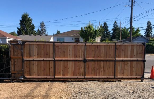 A wooden fence is sitting in the middle of a dirt field.