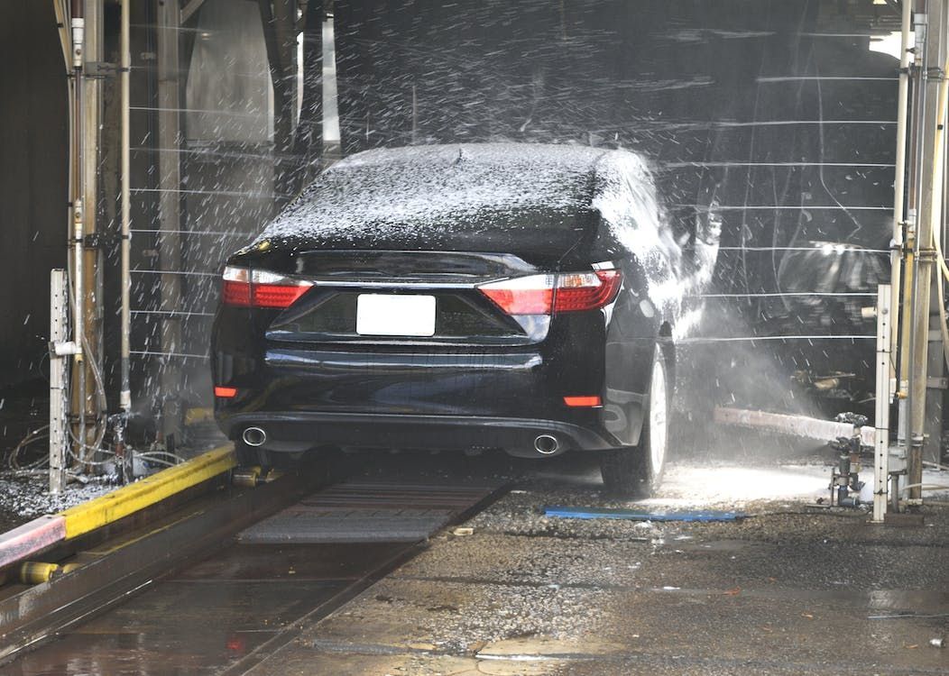 a black car is being washed in a car wash .
