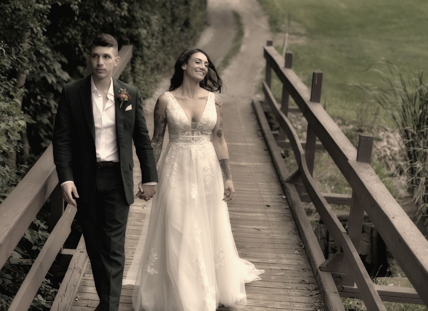 A bride in a wedding dress and veil is standing on a rocky beach near the ocean.