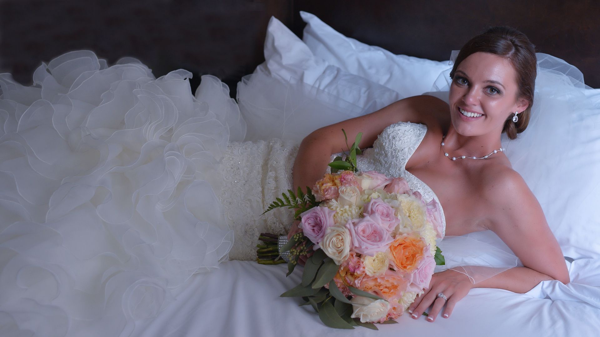 A bride and groom are posing for a picture in a field.