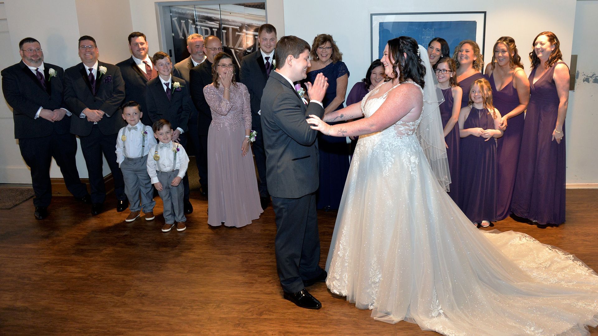 A black and white photo of a bride and her dog looking out of a window.