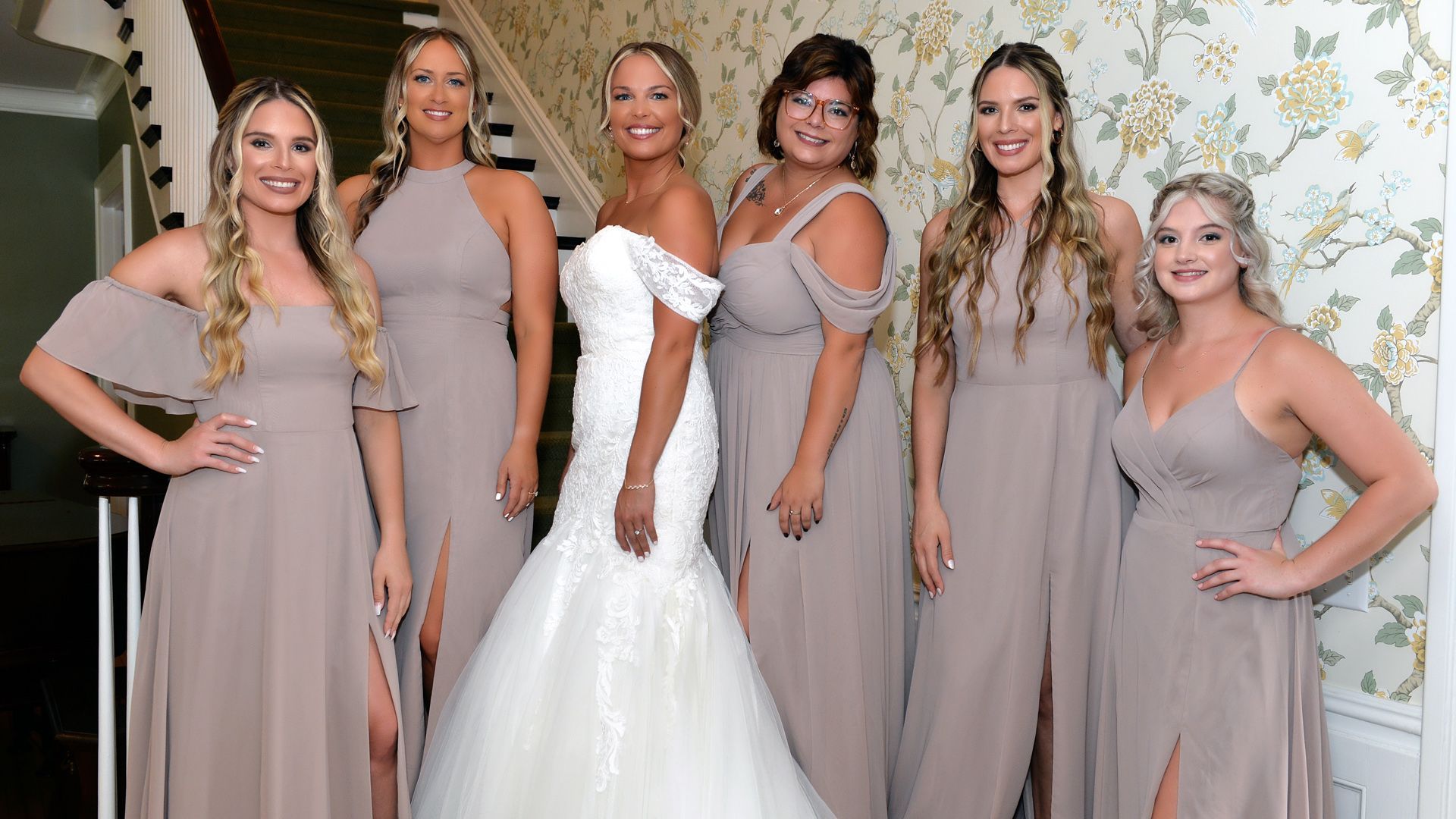 The bride is wearing a veil and holding a bouquet of flowers.