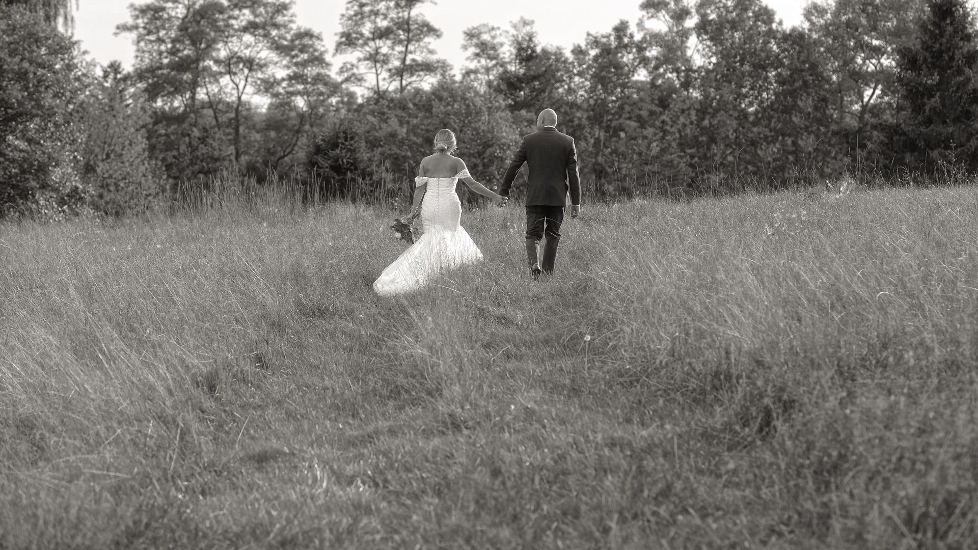 A man is being lifted in the air by a group of people at a wedding reception.