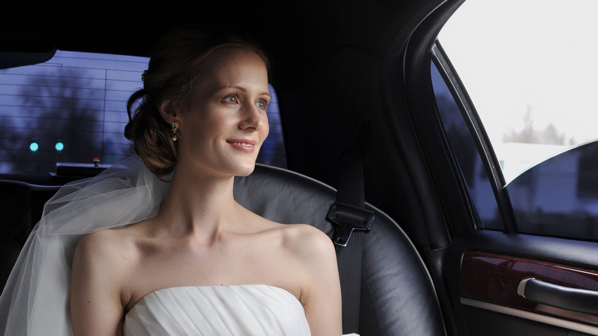 A bride and groom kissing in front of their wedding party.