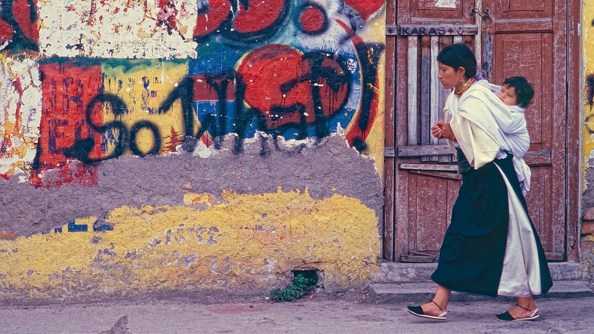 A group of people are walking down a dirt road in the desert.
