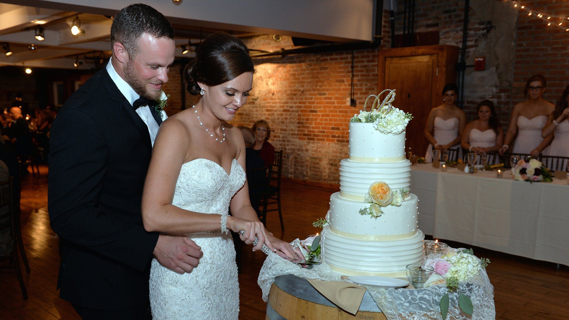 A bride and groom are cutting their wedding cake.