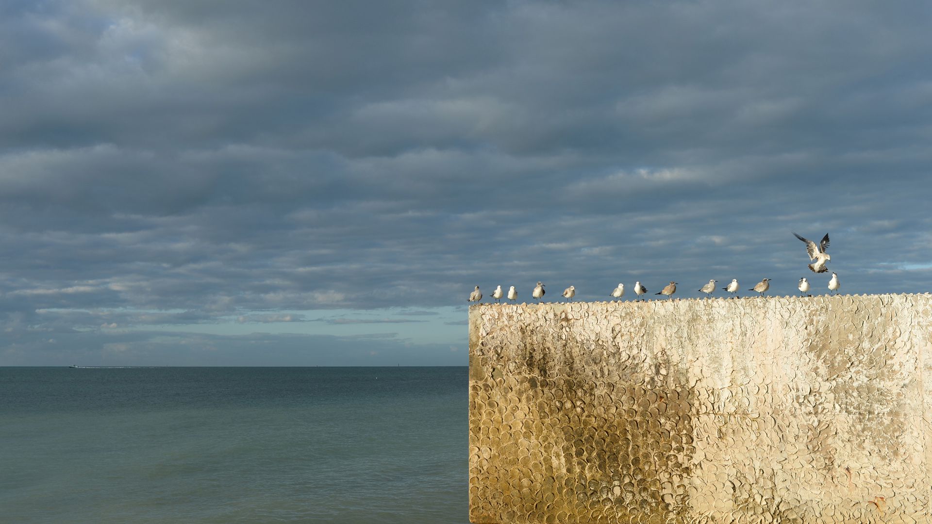 There is a large rock formation in the middle of the ocean.