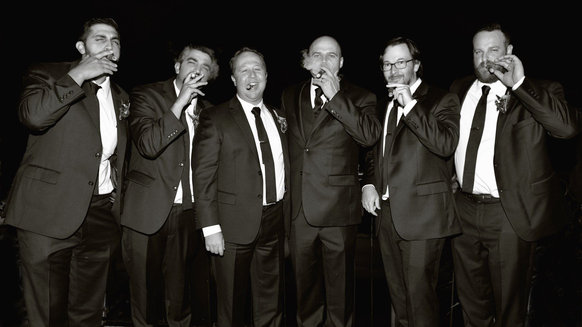 A group of men in suits and ties are standing next to each other.