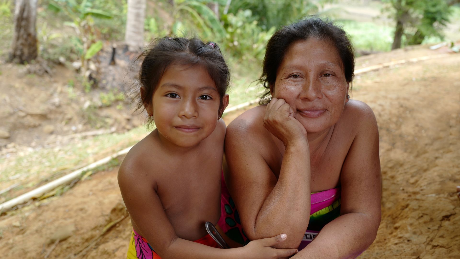 A woman and a young girl are posing for a picture.