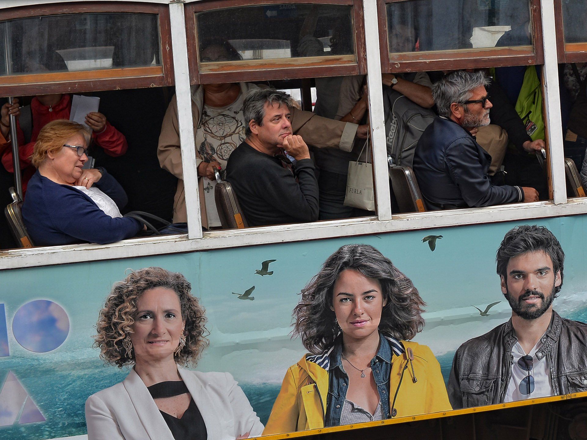 A group of people are sitting on a bus looking out the windows