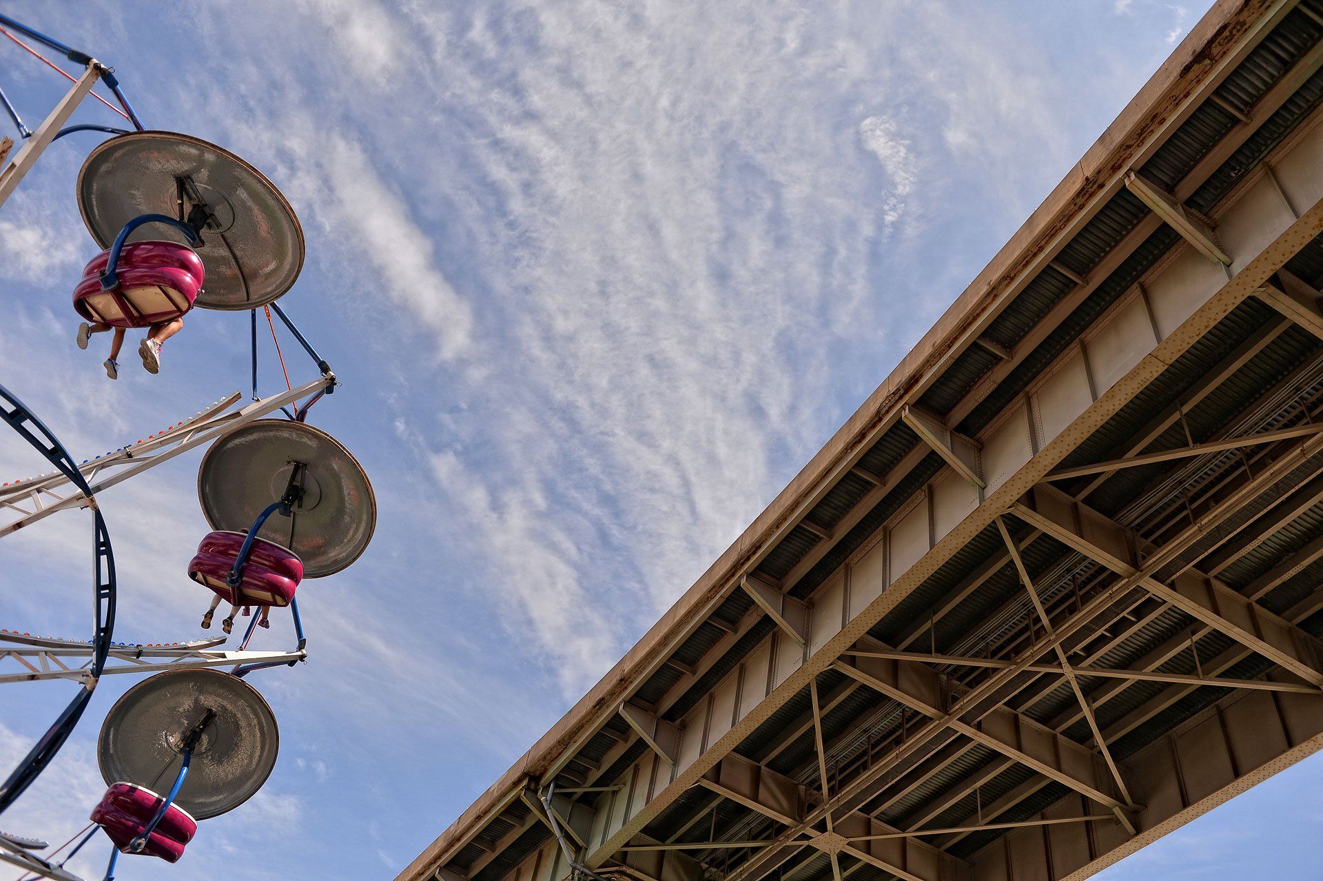 People are riding a ferris wheel under a bridge
