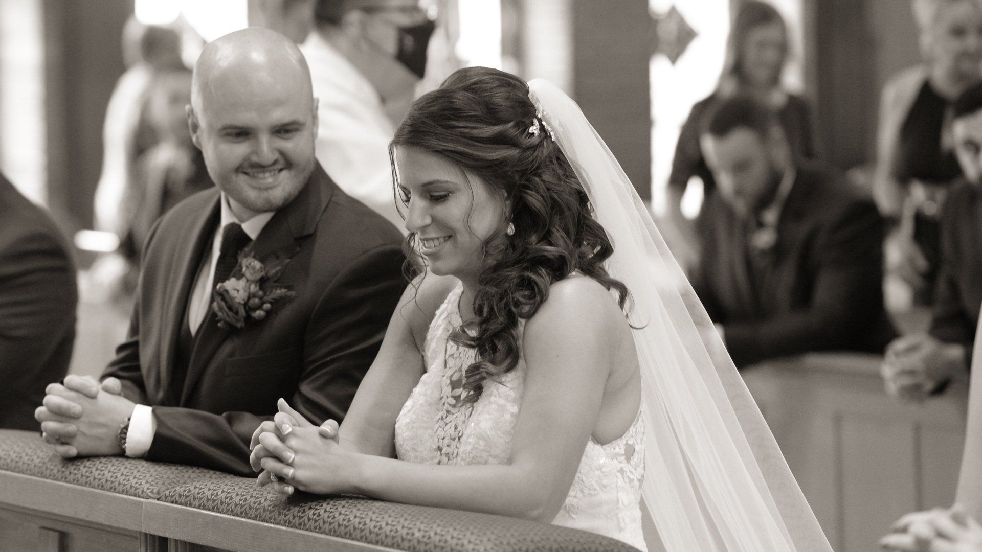 A bride and groom are praying in a church during their wedding ceremony.