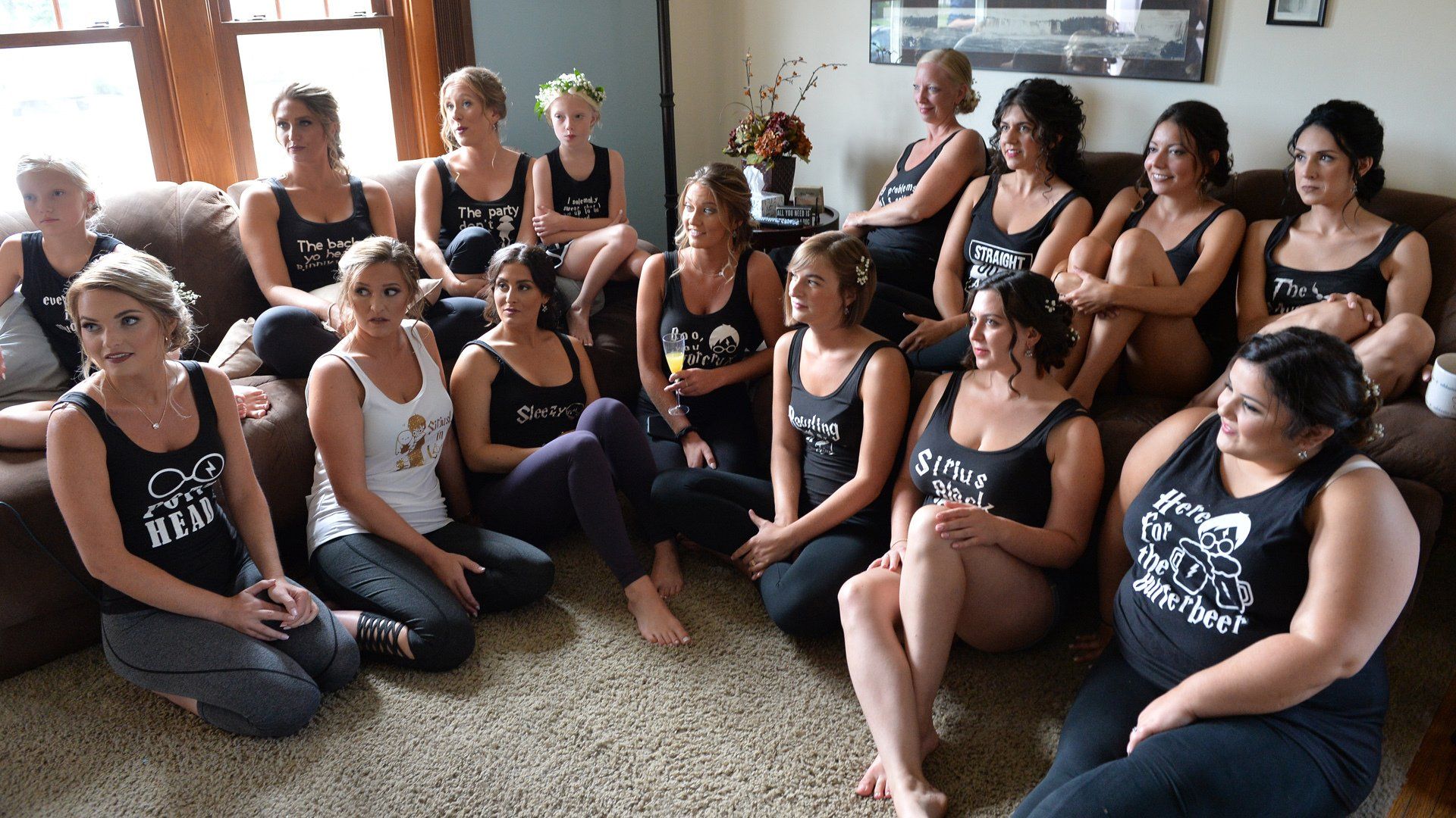 A group of women are sitting on the floor in a living room.