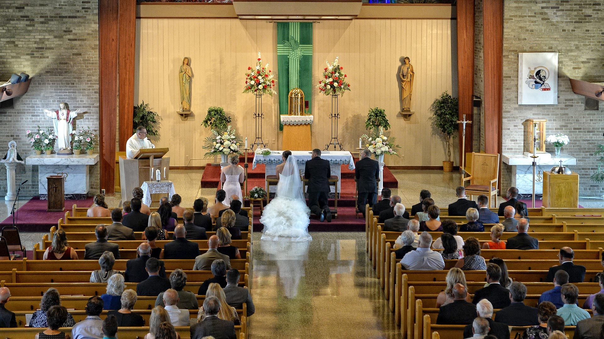 A bride and groom are getting married in front of a crowd of people in a church.