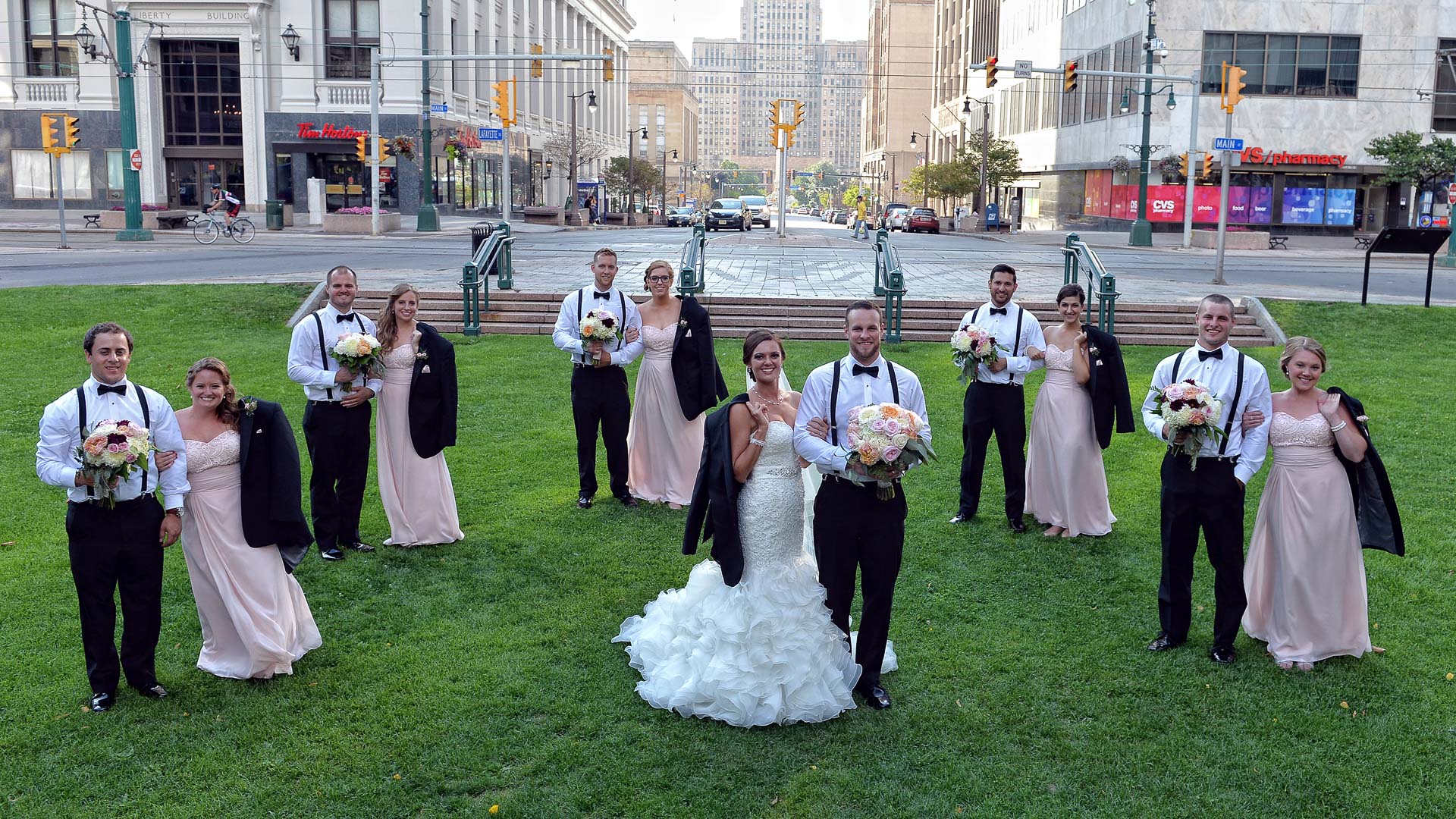 A bride and groom are posing for a picture with their wedding party.