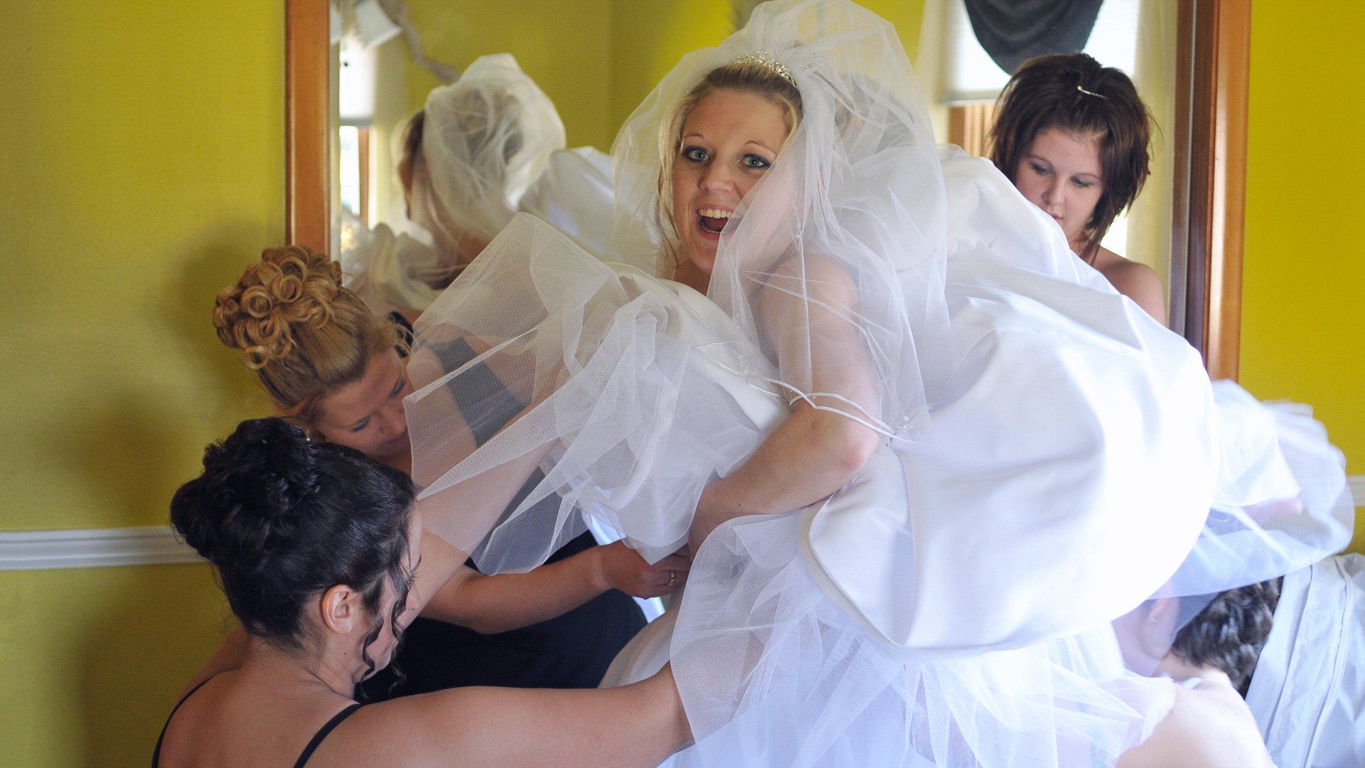 A group of women are helping a bride get ready for her wedding