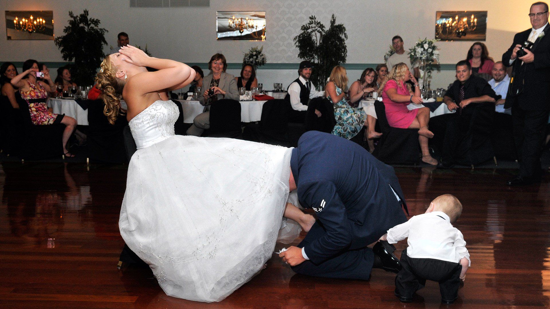 A bride and groom are dancing in front of a crowd of people