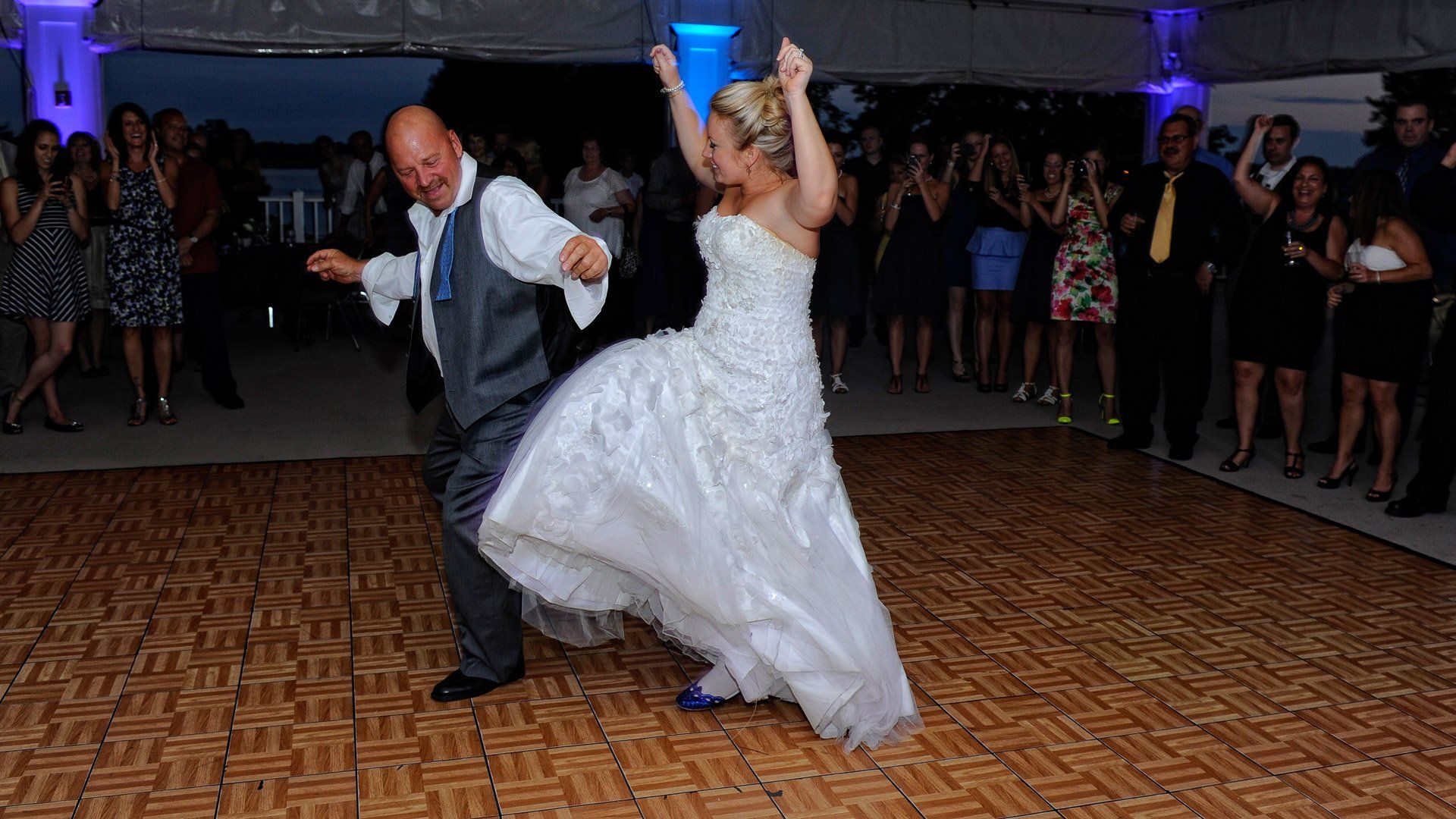 A bride and groom are dancing on a dance floor at their wedding reception.