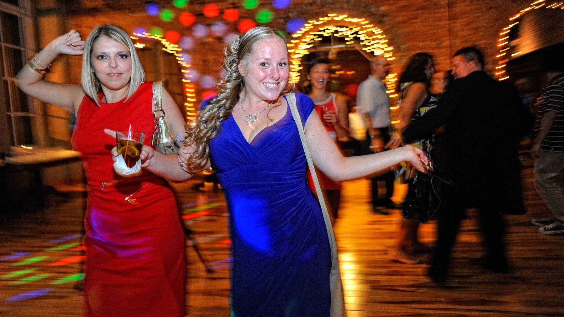 Two women are dancing on a dance floor at a party.