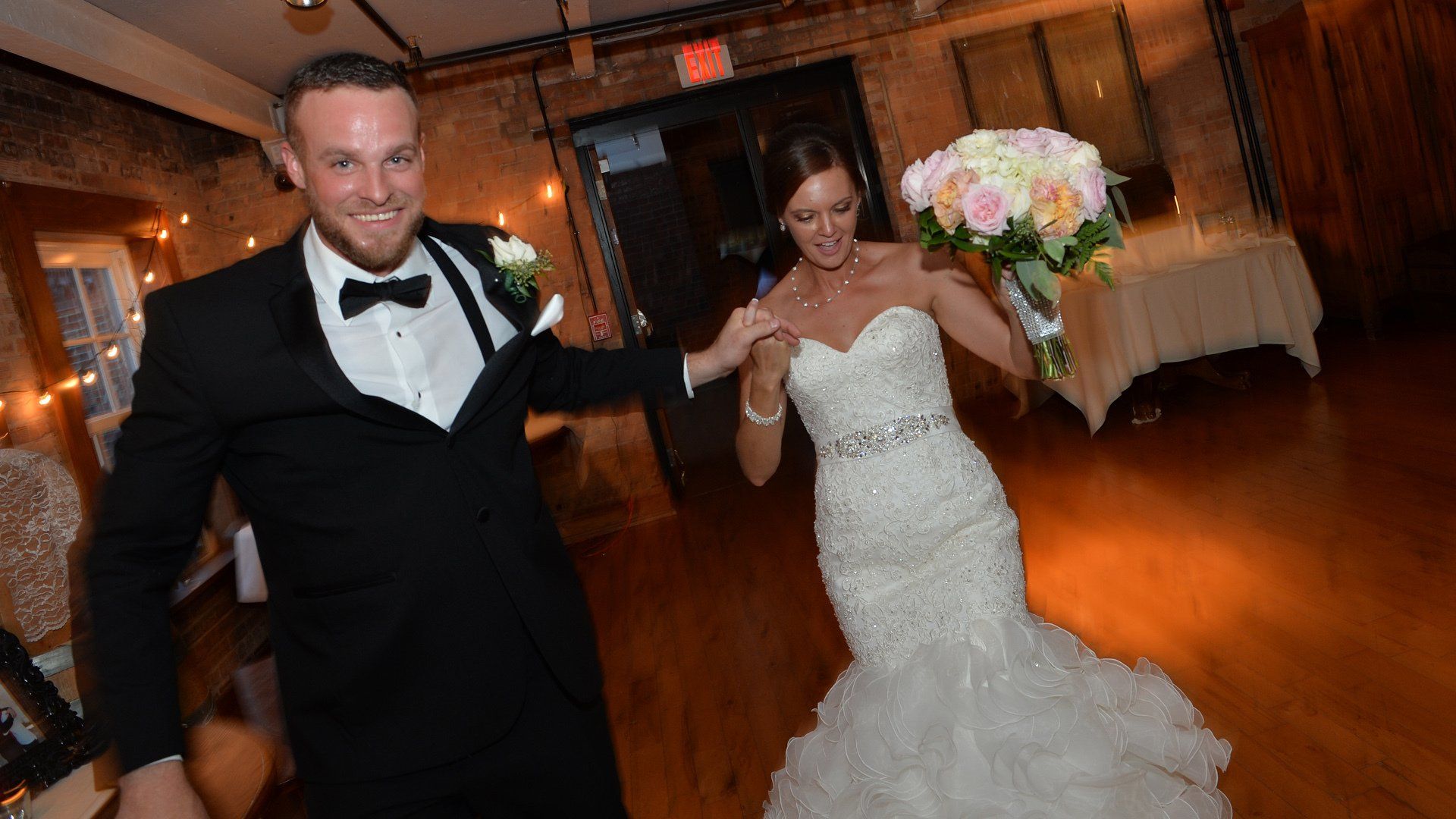 A bride and groom are dancing together at their wedding reception.