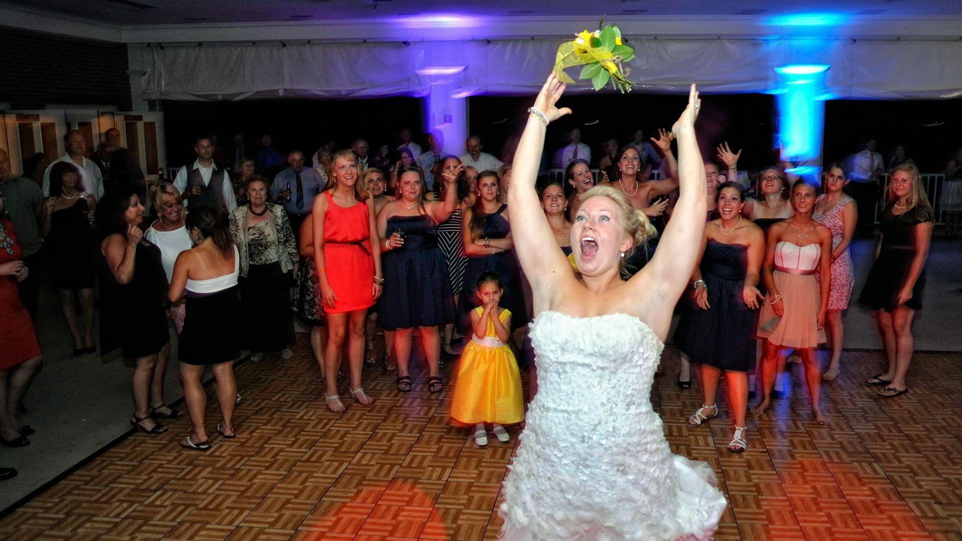 A bride and groom are posing for a picture in front of a fountain.