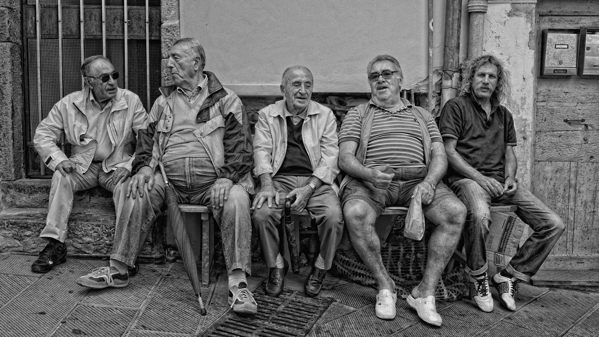 Two men standing next to a sign that says hay