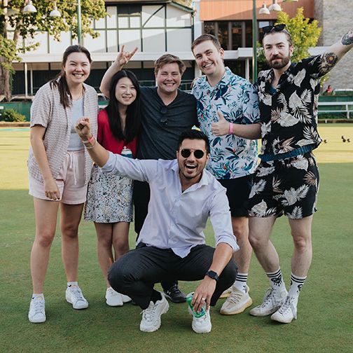 Six bowling wearing Hawaiian shirts smile for the camera. 