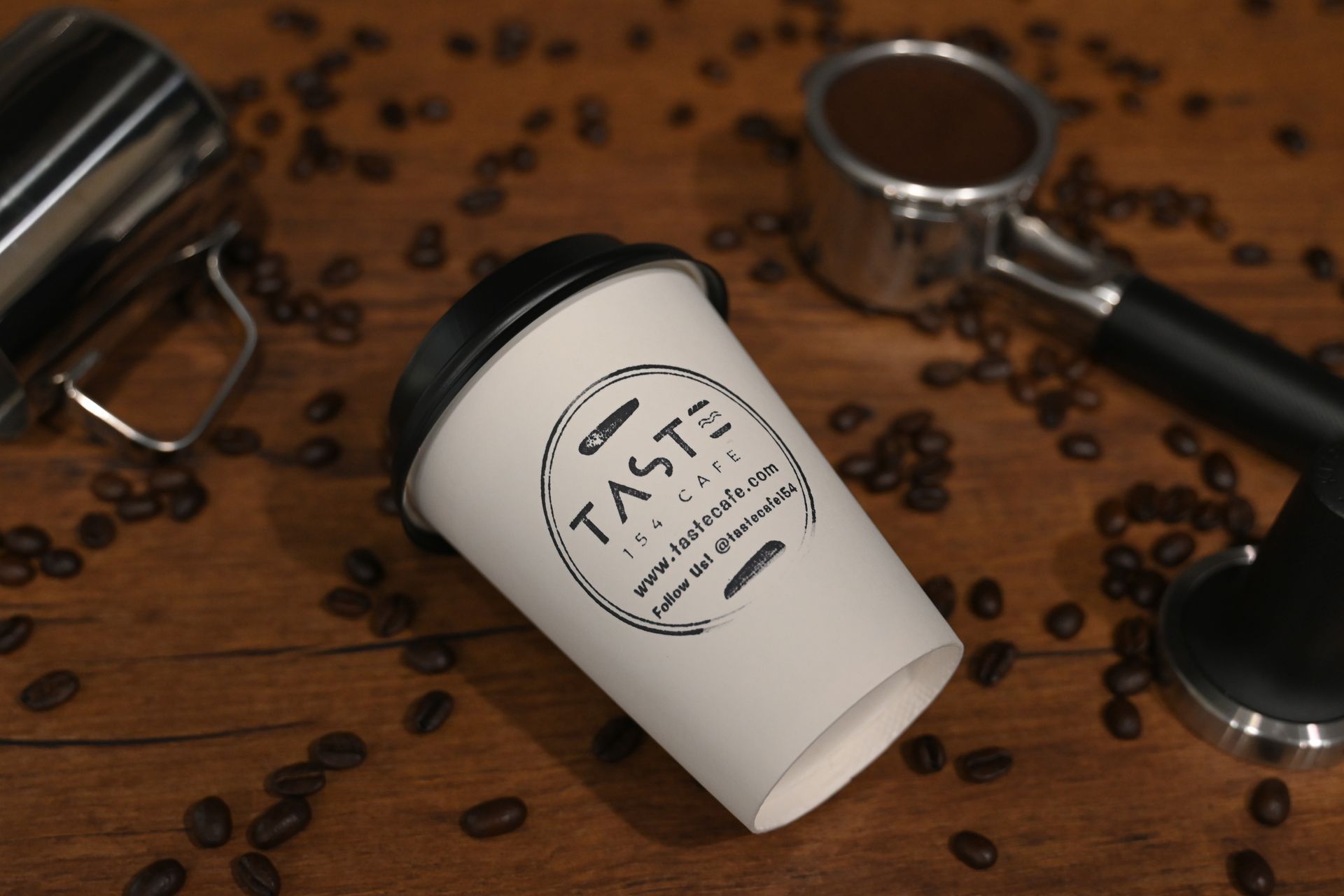 A cup that says taste is surrounded by coffee beans