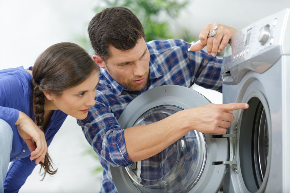 A man pointing the inside of a dryer