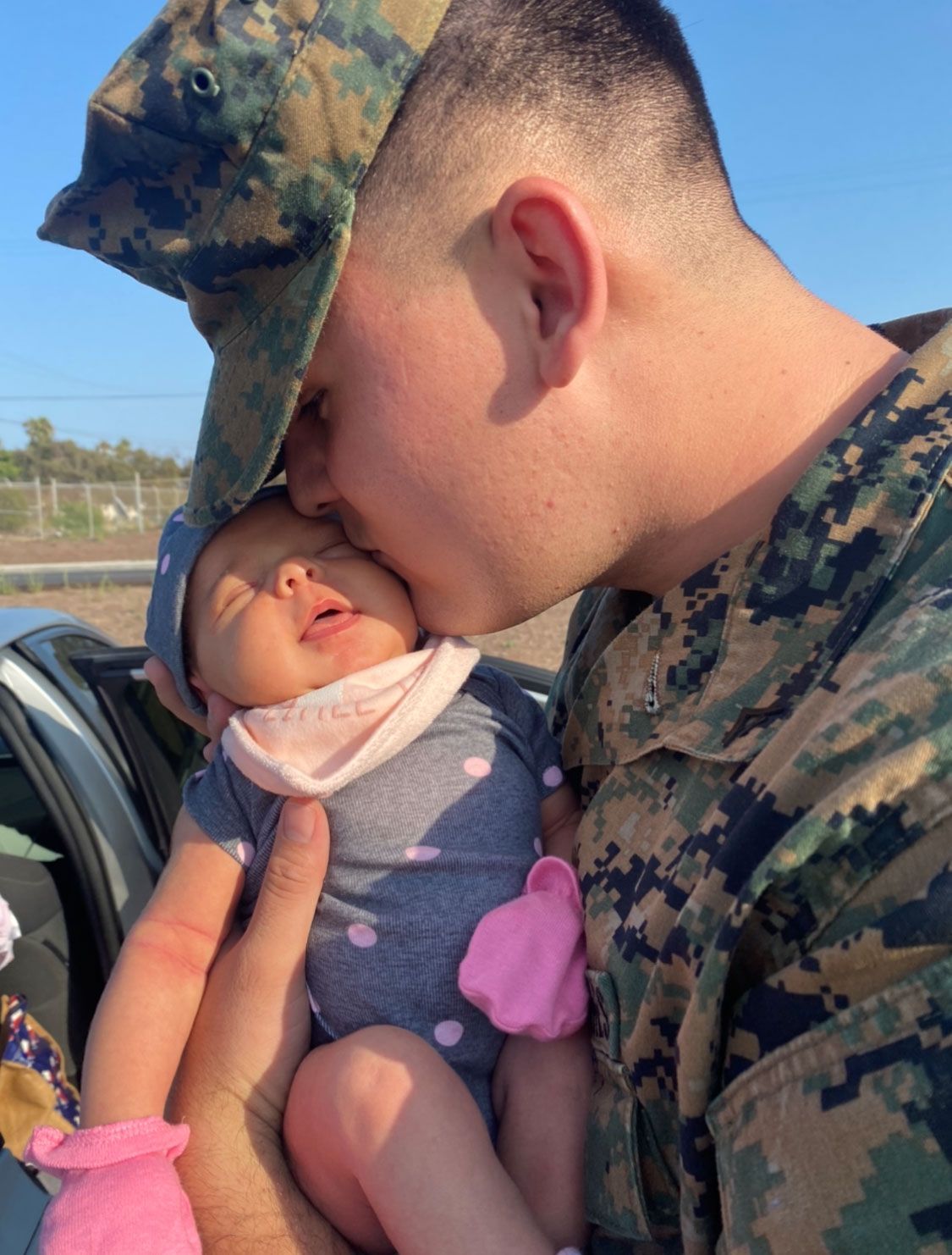 Man in a Military Uniform Kissing a Baby — San Antonio, TX — Camacho’s Moving