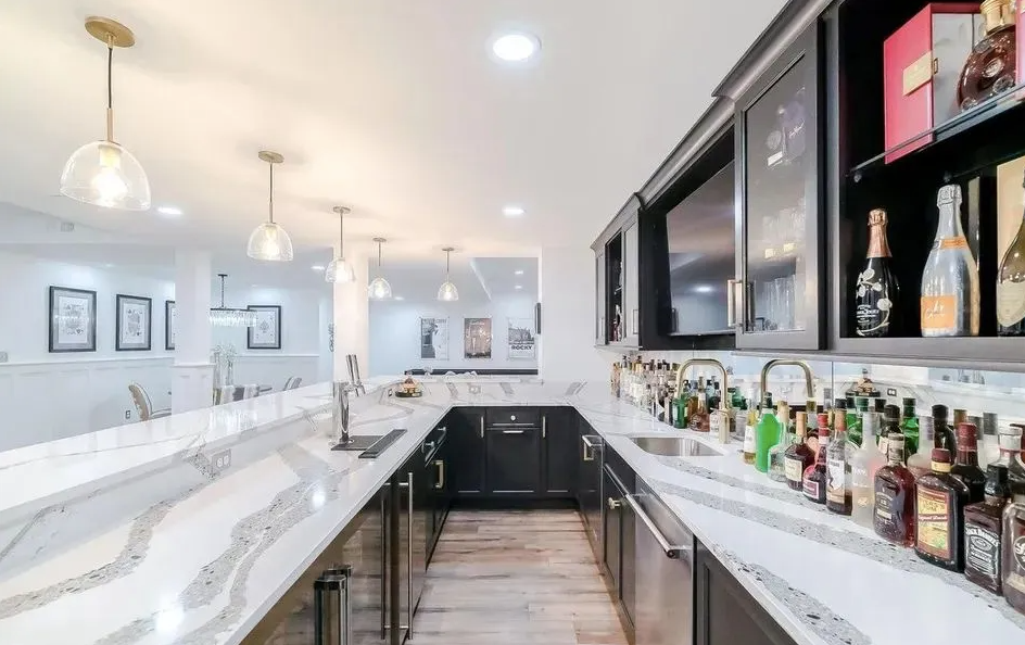 A kitchen with a large island and lots of black chairs.