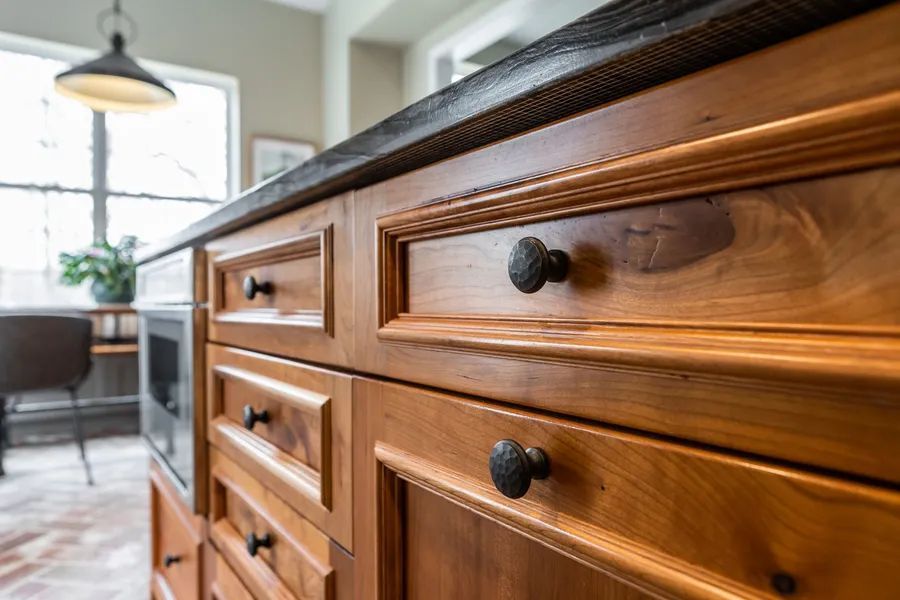 A kitchen with wooden cabinets and black granite counter tops.