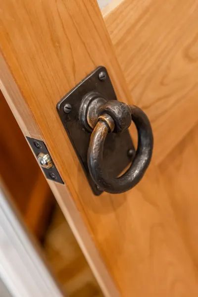 A close up of a door handle on a wooden door.