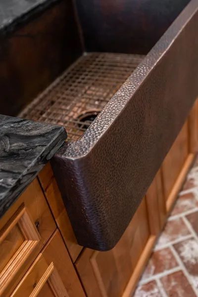 A kitchen sink is sitting on top of a wooden cabinet.