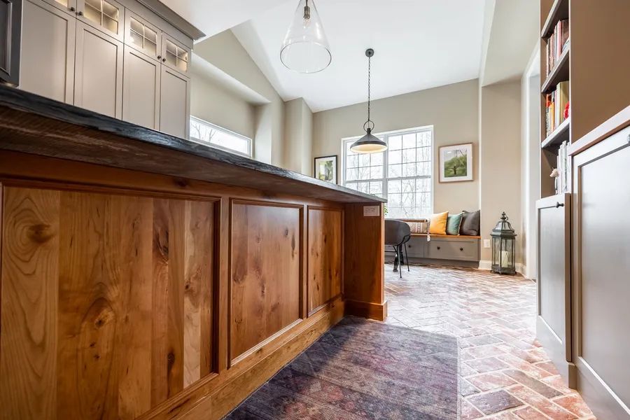 A kitchen with wooden cabinets and a large island in the middle of the room.