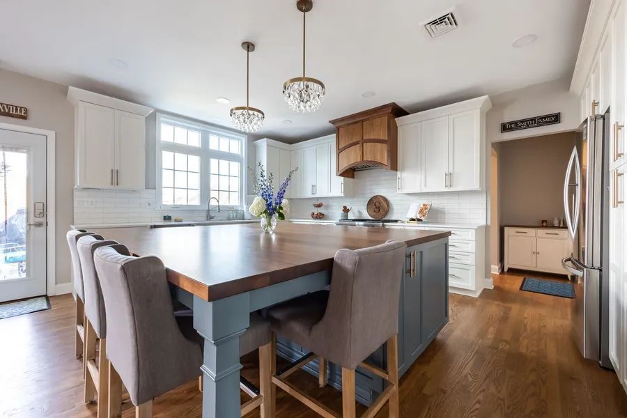 There is a large island in the middle of the kitchen with a table and chairs.