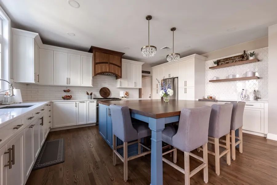 There is a large island in the middle of the kitchen with a table and chairs.