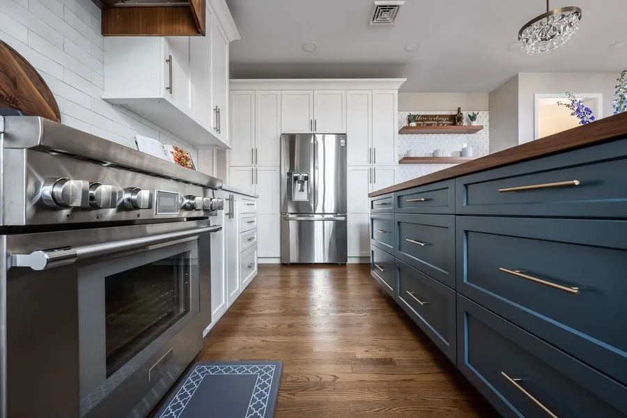 A kitchen with stainless steel appliances and blue cabinets.