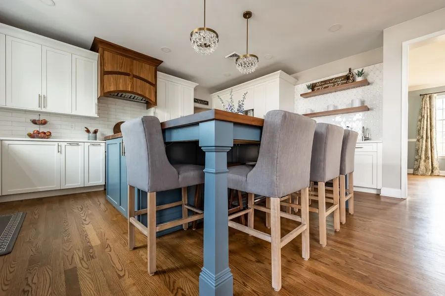 A kitchen with a blue table and gray chairs.