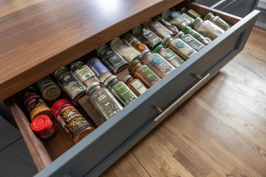 A drawer filled with lots of spices in a kitchen.