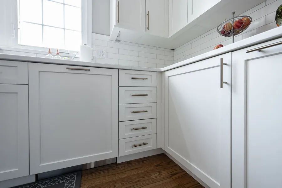 A kitchen with white cabinets and stainless steel appliances.