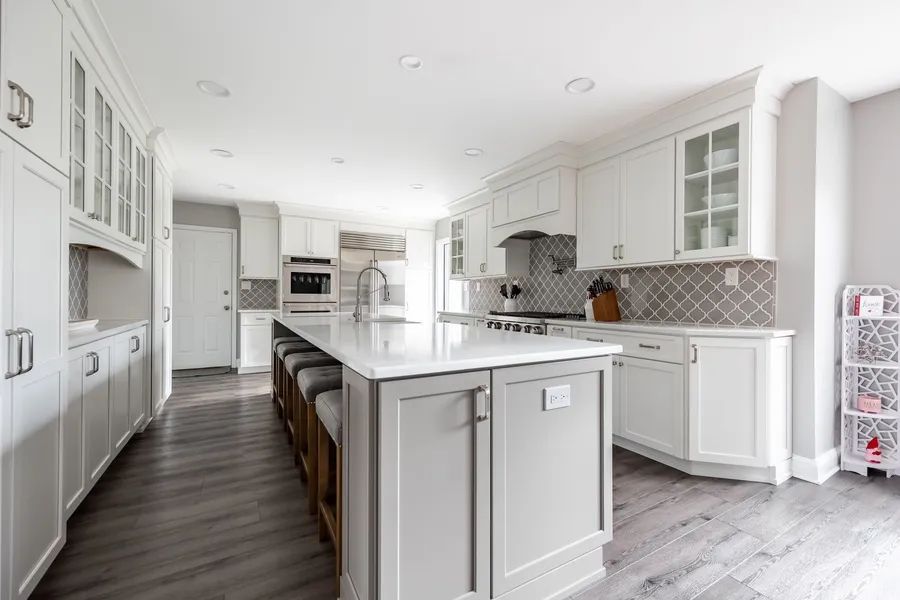 A kitchen with white cabinets and a large island.