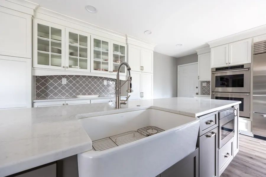 A kitchen with a large white sink and stainless steel appliances.