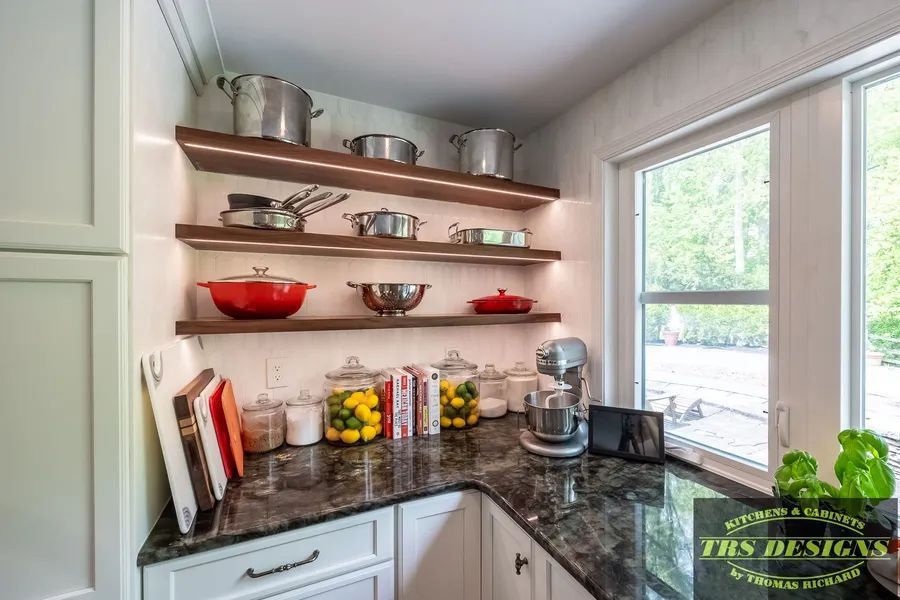 A kitchen with pots and pans on shelves and a window.