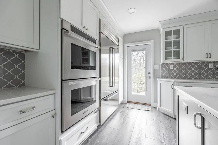 A kitchen with white cabinets and stainless steel appliances.