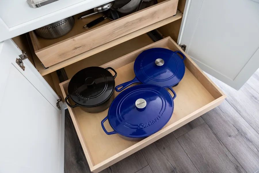 A kitchen drawer filled with pots and pans.