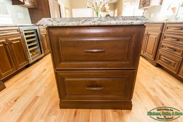 A kitchen with wooden cabinets and a granite counter top.