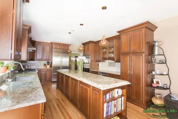 A kitchen with wooden cabinets and granite counter tops.