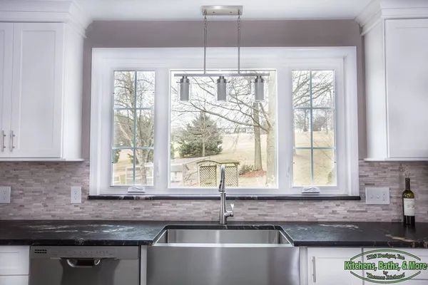 A kitchen with a stainless steel sink and a large window.