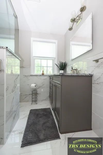 A bathroom with a sink, mirror, and rug.